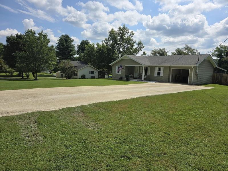 A new gravel driveway leading up to a home and garage