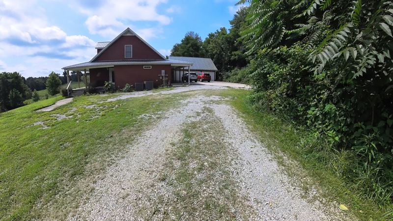 A gravel driveway with grassy ruts before regrading
